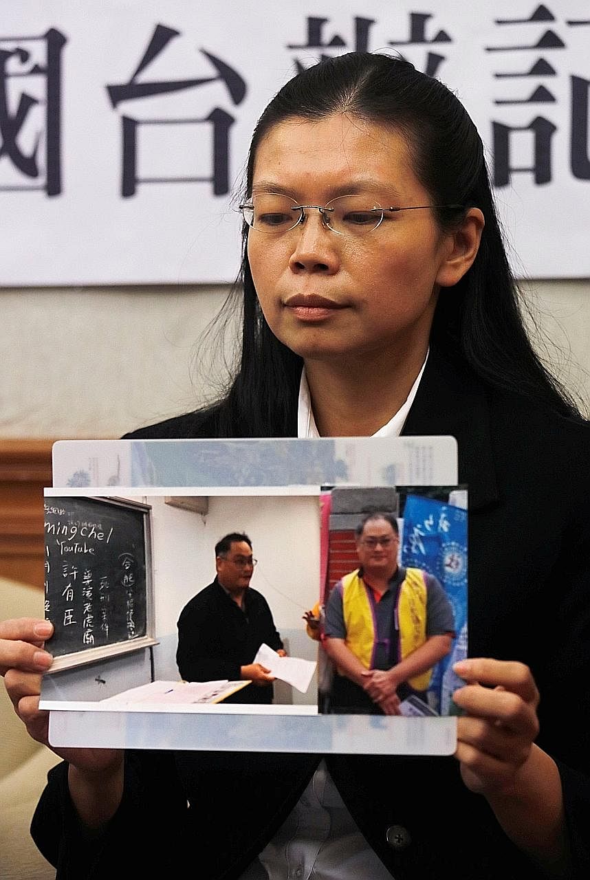 Ms Lee Ching-yu with photos of her husband during a news conference in Taipei yesterday.