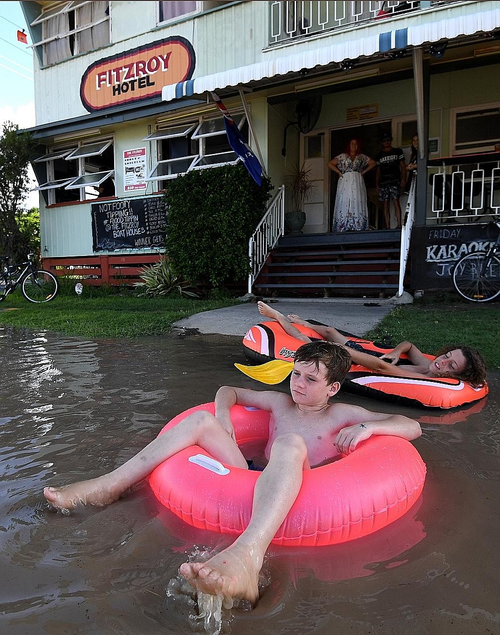 Children in Rockhampton, Queensland, playing in flood waters left in the wake of Cyclone Debbie yesterday. The disaster caused billions of dollars in damage to various sectors in Australia.