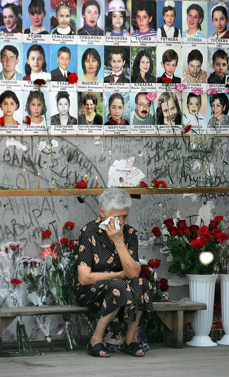 A 2009 file photo showing a woman at the Beslan school gymnasium mourning the victims of the 2004 siege by Chechen rebels, on the fifth anniversary of the incident. The school was stormed on Sept 1, 2004, by militants demanding the withdrawal of Russ