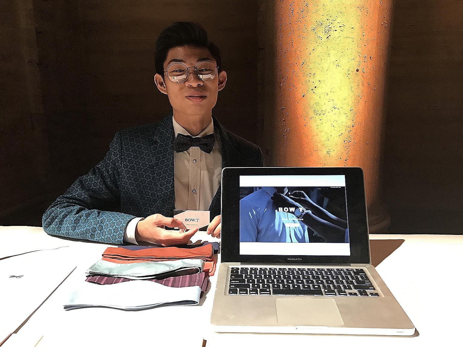 Arif Hamzah at his booth (above) in New York City, where he represented Singapore in an entrepreneurship challenge. His business idea, Bow T., is to make affordable bow ties from leftover fabric and sell them. His mentor, Mr Wong U-Yun (below, with A