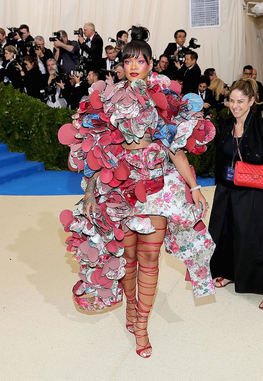 Singer Rihanna in a kaleidoscopic Comme des Garcons dress with swirling layers of floral flounces.