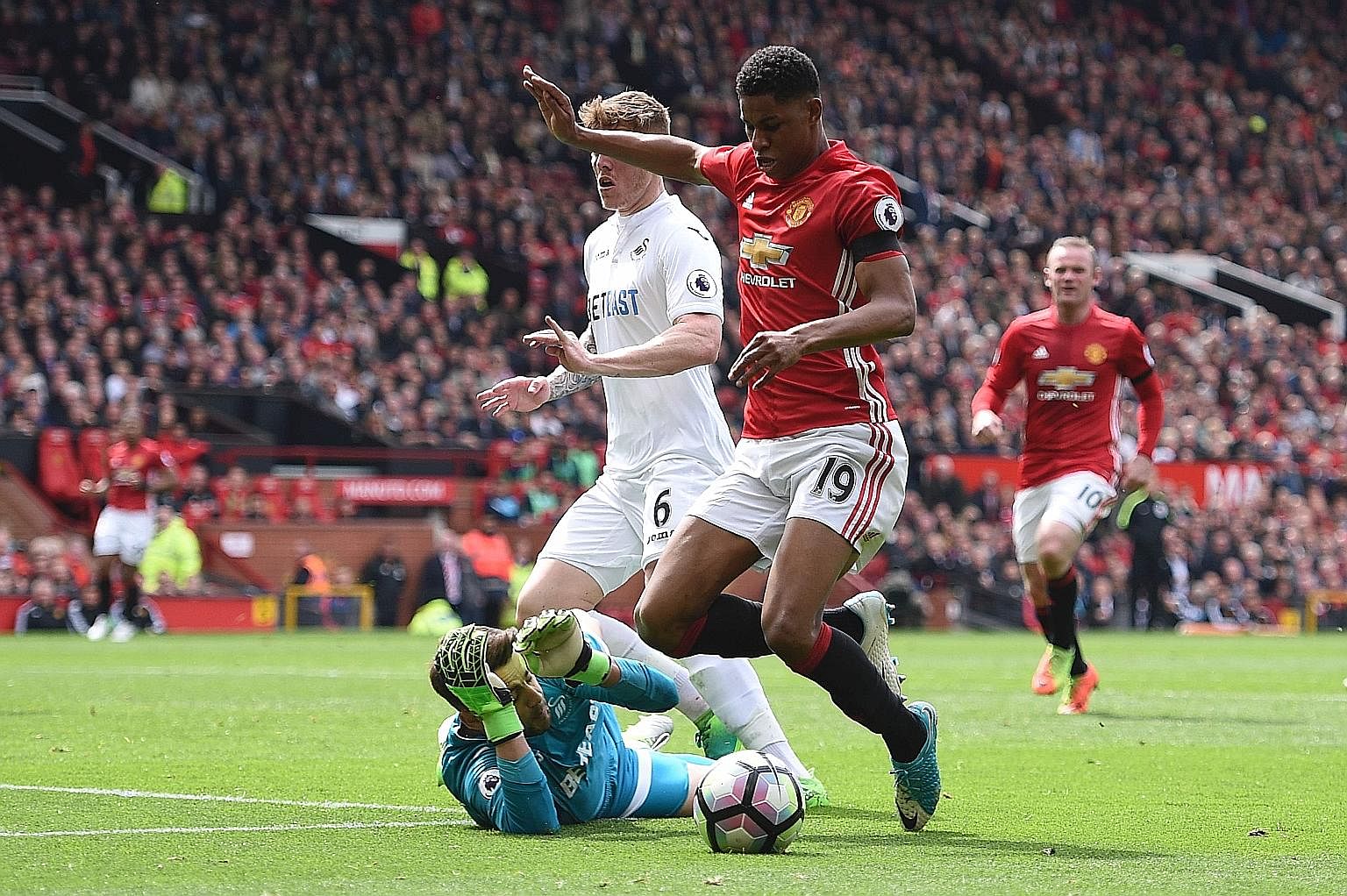 Manchester United's English striker Marcus Rashford goes down as Swansea goalkeeper Lukasz Fabianski pulls his arms away. His dive earned his side a penalty in the English Premier League clash.