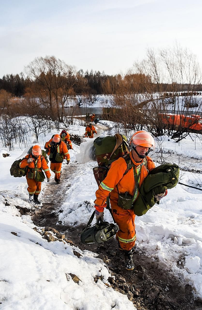 Chinese firefighters leaving the Bilahe Beidahe Forest. A sudden heavy snowfall overnight on Saturday covered the forest in Inner Mongolia with an 18cm blanket of snow, helping to douse a massive forest fire in the mountainous region near the Russian