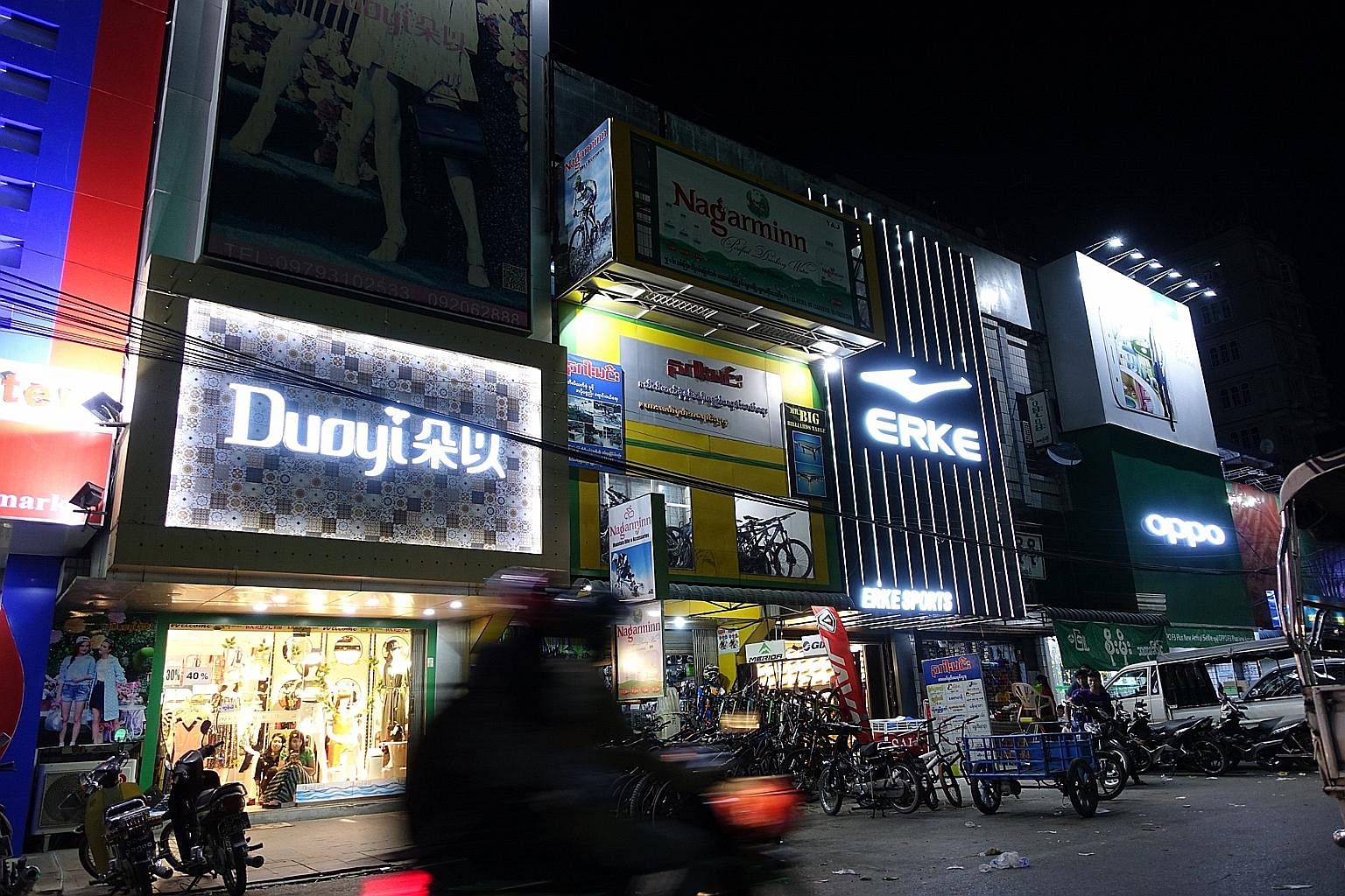 Advertisements for Chinese brands light up downtown Mandalay. The former royal capital, once lined with traditional wooden homes, now bustles with hotpot restaurants and Chinese boutiques selling Duoyi women's fashion, Erke sportswear and Oppo smartp