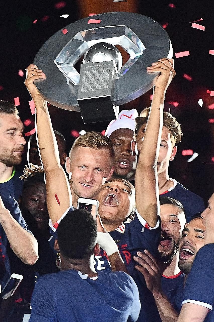 Monaco forward Kylian Mbappe hoisting the Ligue 1 trophy after they beat Saint Etienne 2-0 on Wednesday. He opened the scoring and substitute forward Valere Germain sealed the win for the side's first French league title in 17 years.