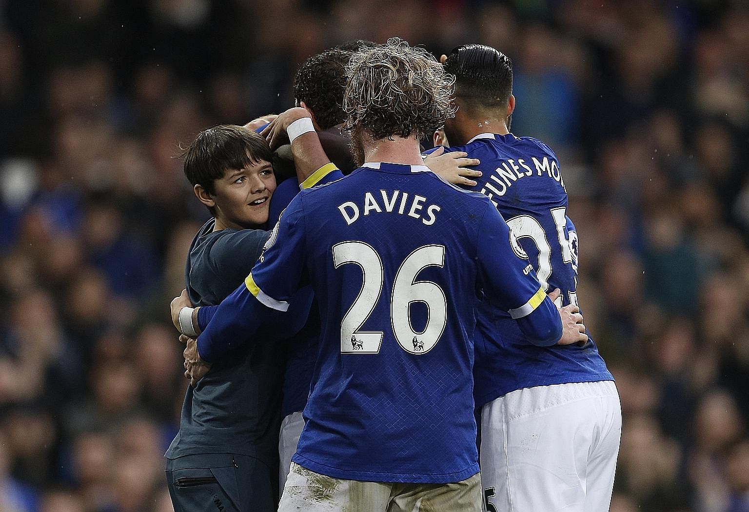 A young Everton fan invades the pitch to celebrate with Romelu Lukaku after the striker scored the club's last goal in the 3-0 victory against West Bromwich Albion in their Premier League encounter on March 11.