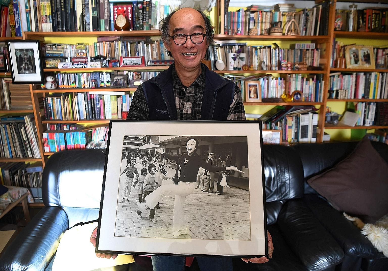 Mr Philip Fok with a photo of himself in his younger days as a mime artist in Hong Kong. He emigrated to Sydney in 1992. Hong Kong residents holding up placards with words depicting their feelings about the city as the 20th anniversary of its handove
