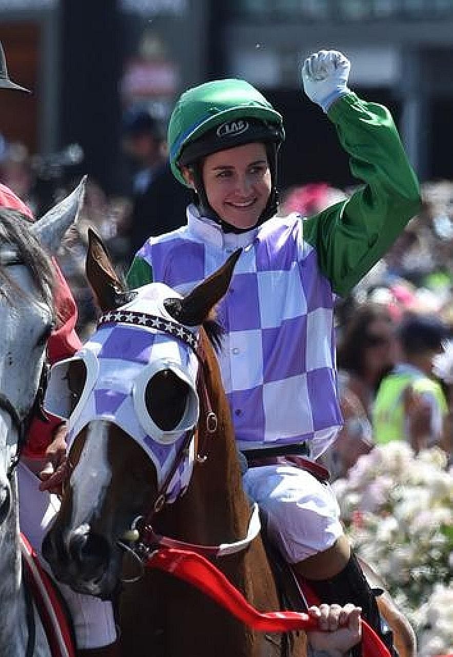 Jockey Michelle Payne punching the air after becoming the first female jockey to win the 155-year-old Melbourne Cup in 2015.