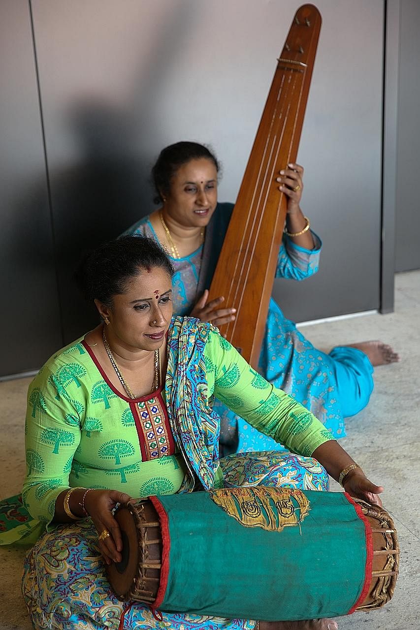 Twin sisters Chandrakala Kunaseelan, holding a double-headed drum called the mridangam, and Shashikala Samugan Nathan, holding a long-necked plucked string instrument called the tambura. The 45-year-old granddaughters of the late percussionist M.V. G