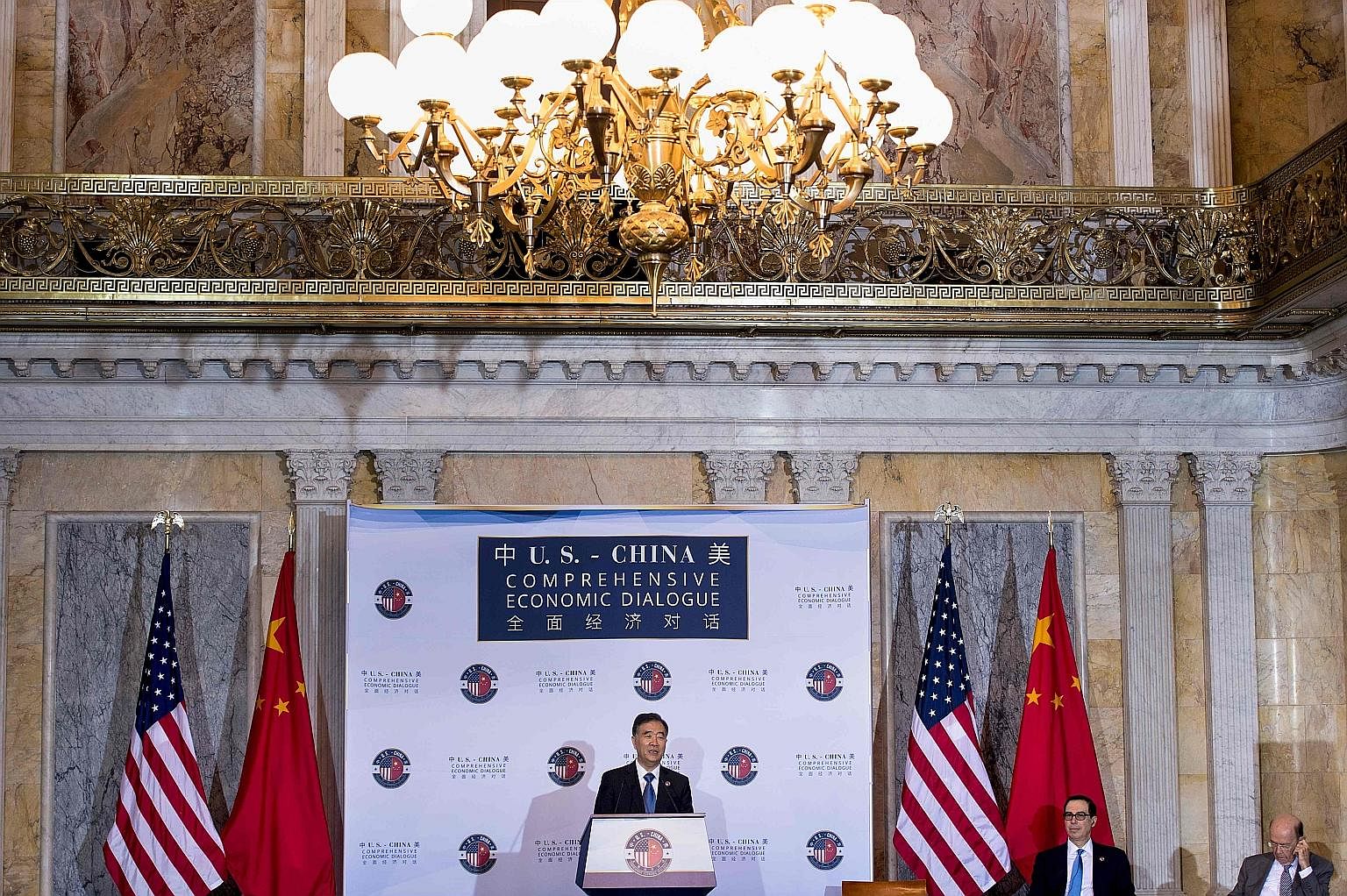 China's Vice-Premier Wang Yang speaking at the economic dialogue on Wednesday in Washington, as US Treasury Secretary Steven Mnuchin and Commerce Secretary Wilbur Ross (far right) listened.