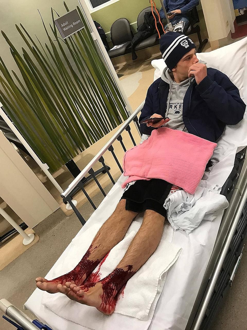 Sam Kanizay waiting in a Melbourne hospital on Saturday evening. He had waded waist-deep into the water at Brighton Beach and emerged after 30 minutes, bleeding profusely from the calves down.
