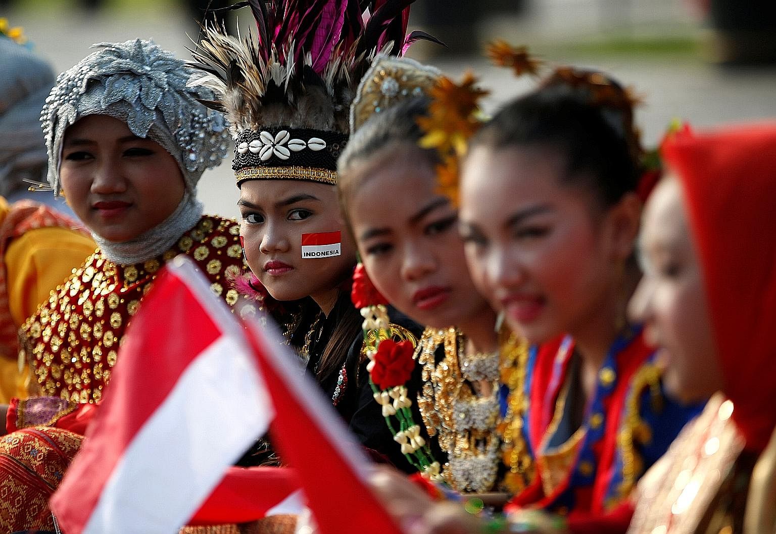 Students in traditional costume waiting for Independence Day celebrations to start at the National Monument in Jakarta yesterday. All three of Mr Joko Widodo's speeches on Wednesday were dominated by the theme of unity.