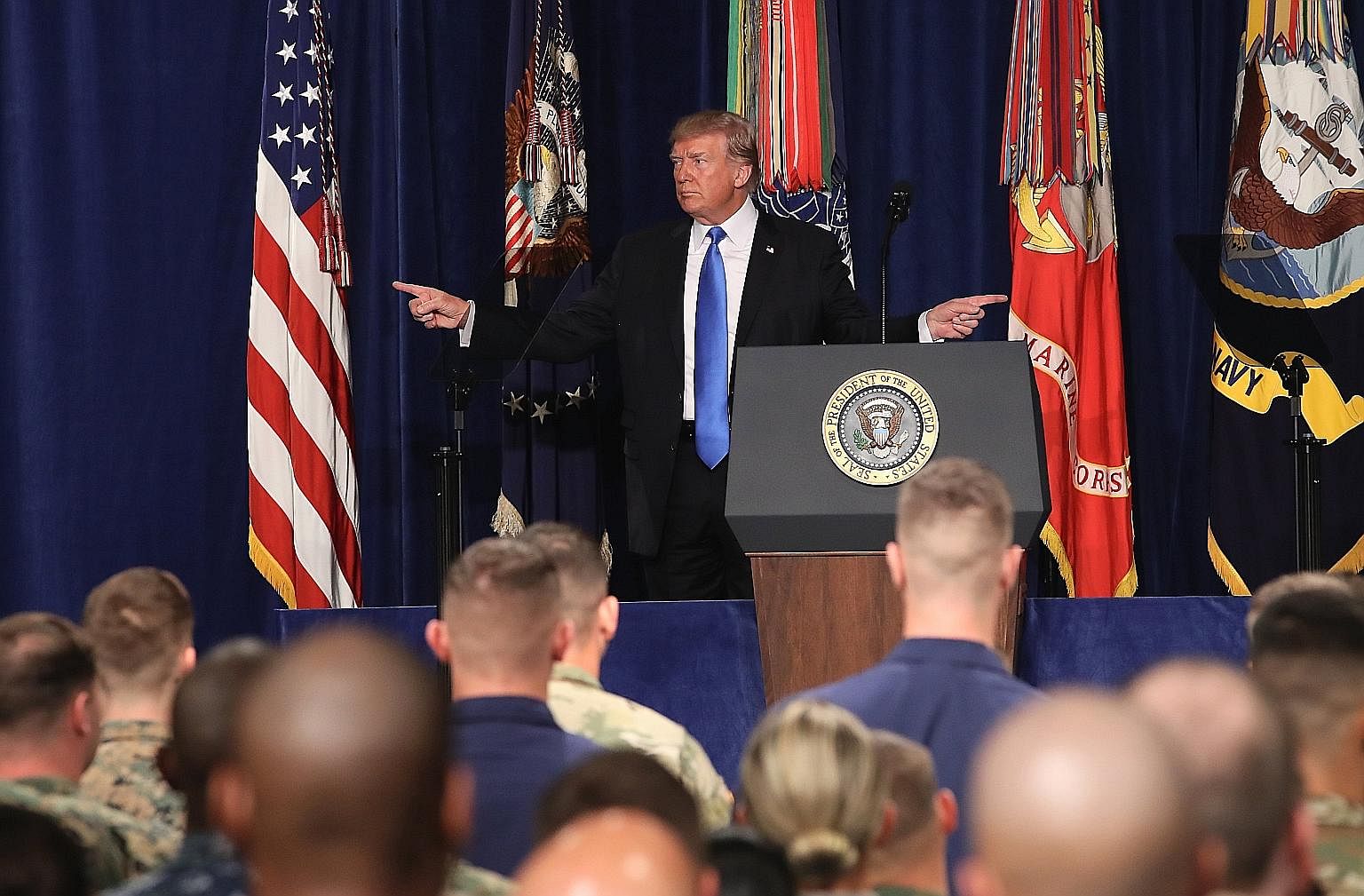 Left: US President Donald Trump before delivering remarks on his country's military involvement in Afghanistan at the Fort Myer base, in Virginia, on Monday. The US is expected to send about 4,000 troops to join the roughly 8,400 in Afghanistan to be