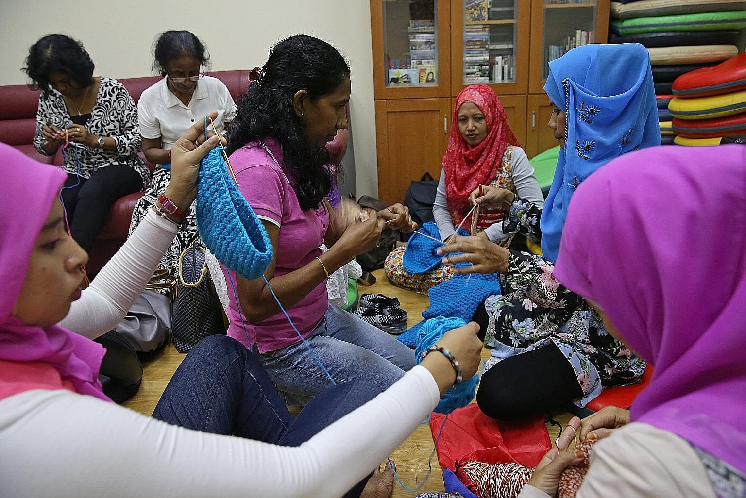 Indonesians Tri Susanty (far left, wearing a purple tudung), 29, Rina Waty (third from right, in a red tudung), 41, and Sunarmi (in a blue tudung), 42, sharing crochet tips with Sri Lankan Chamila, 42, during class. Besides being able to make shawls to pr