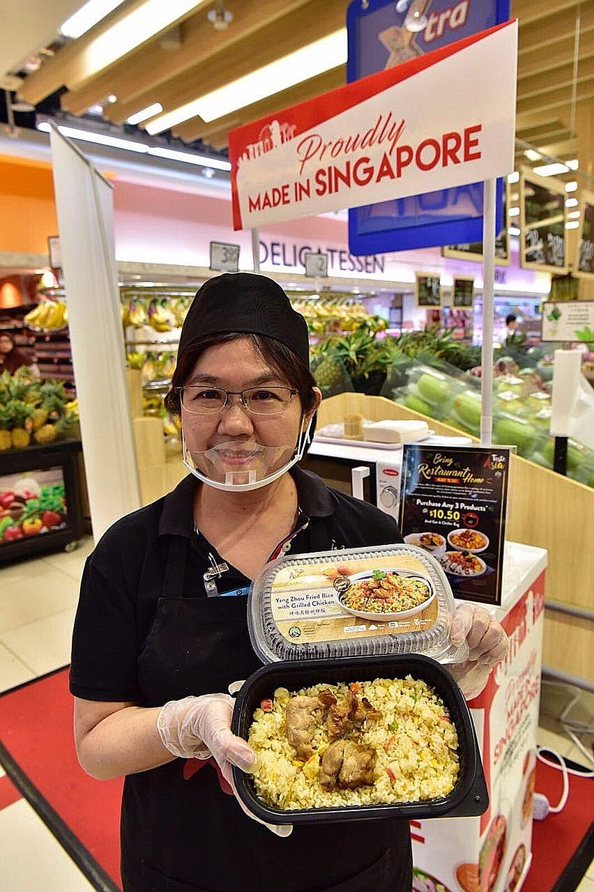 Sales promoter Daphne Lee, 52, with a ready-to-eat meal of Yang Zhou fried rice with grilled chicken, one of the locally made products in FairPrice's Made in Singapore Fair.