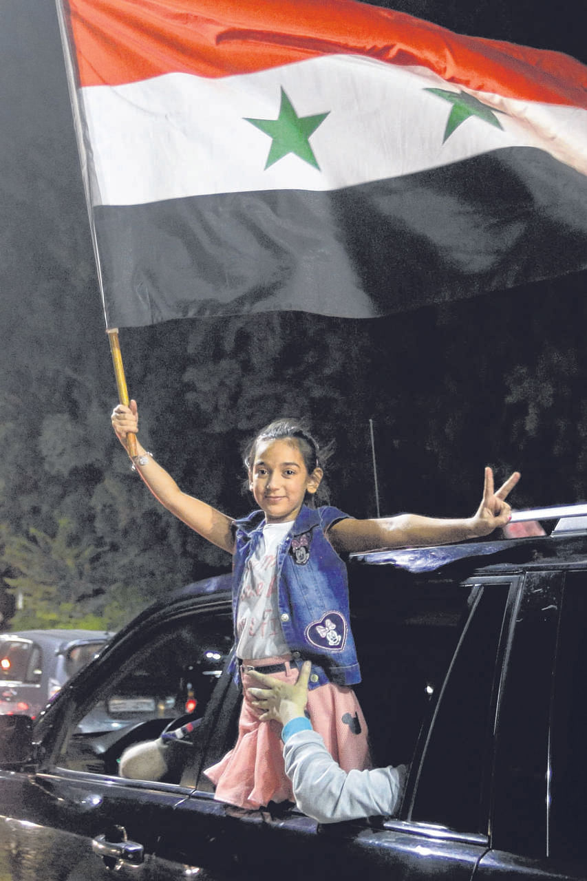 A young Syrian fan celebrates after the national side scored an injury-time equaliser against Iran during a World Cup qualifier.