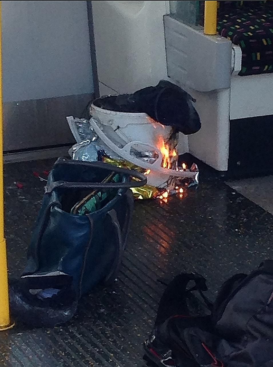 Right: The London Ambulance Service said none of the victims "is thought to be in a serious or life-threatening condition". Above: A photo posted by a Twitter user showing a white bucket burning inside the train carriage.