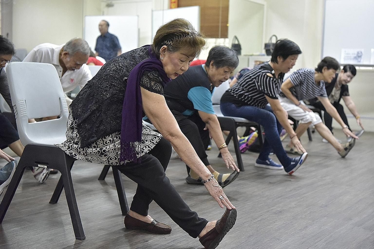 Retiree Kok Ho Moi (far left), 72, who is classified as "pre-frail", keeps herself nimble by taking part in group exercises at the Choa Chu Kang Fei Yue Retirees Centre.