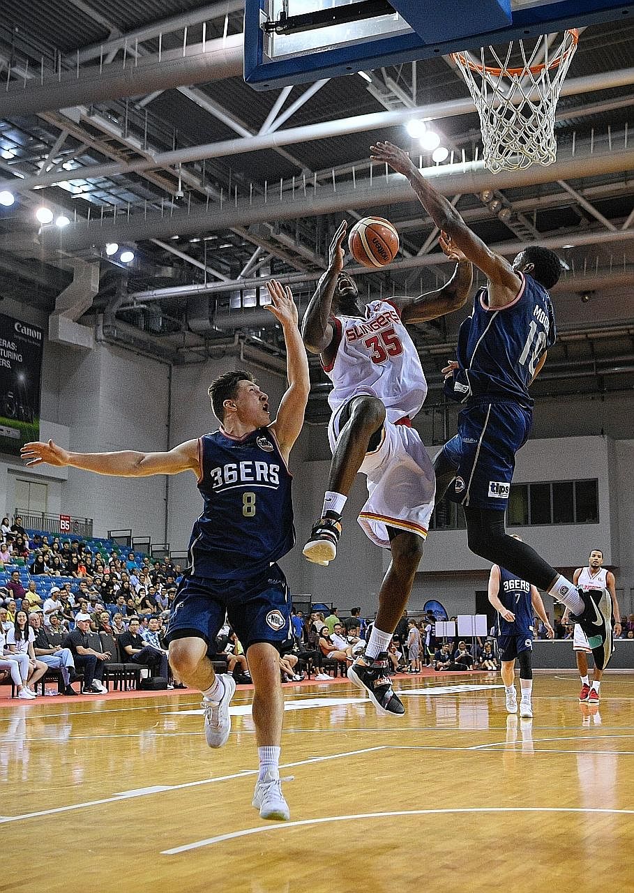 Ryan Wright of the Singapore Slingers going for a shot, as Nelson Larkins (left) and Ramone Moore of the Adelaide 36ers try to block him. The Australian team ran out easy winners 95-52 but the local side also qualified for the semi-finals.