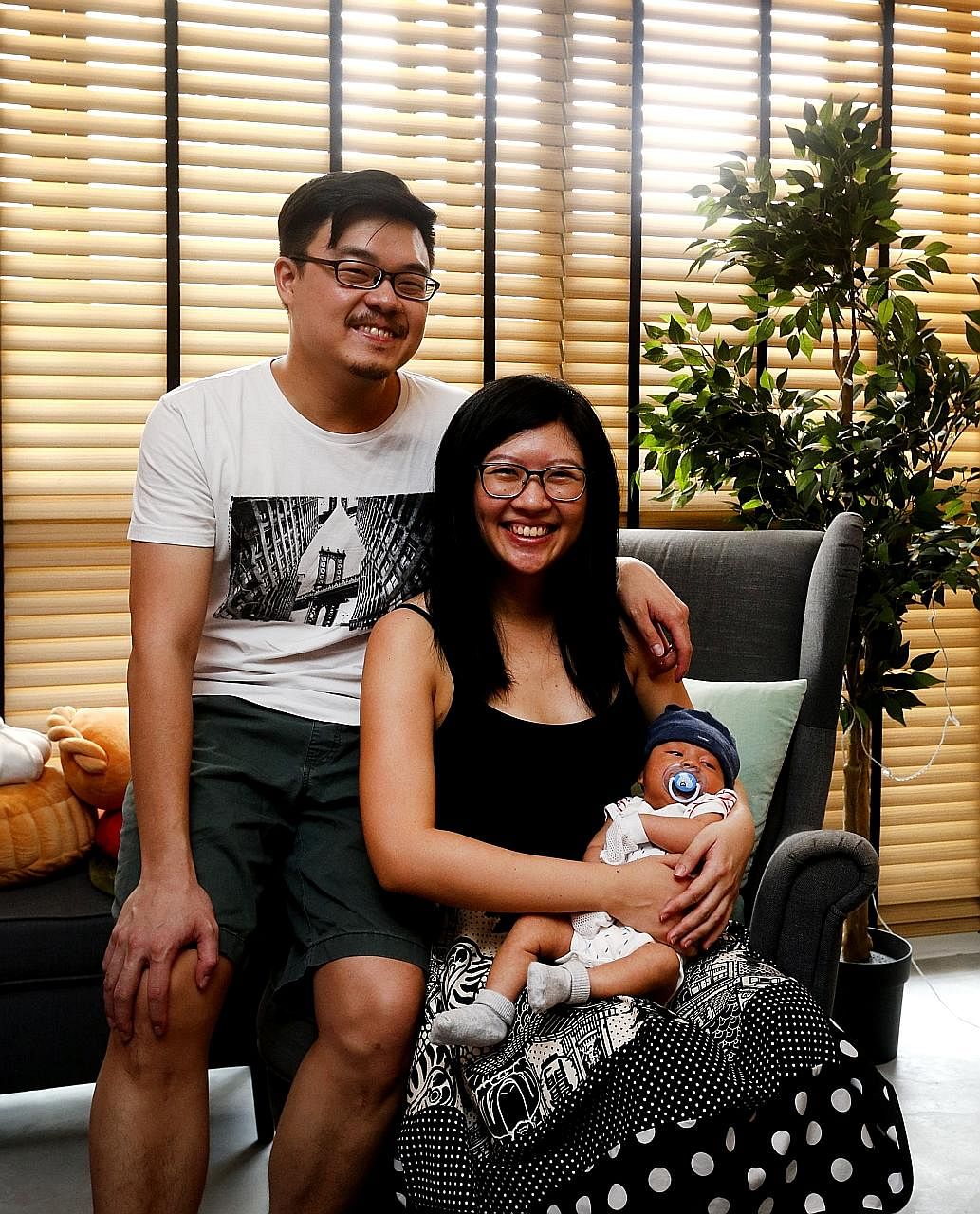 Upcycled wine crates are used as shelves in the living room, especially for the toy collections of home owners Marcus Wong and Gayle Tan (above, with their son, Logan Finn).