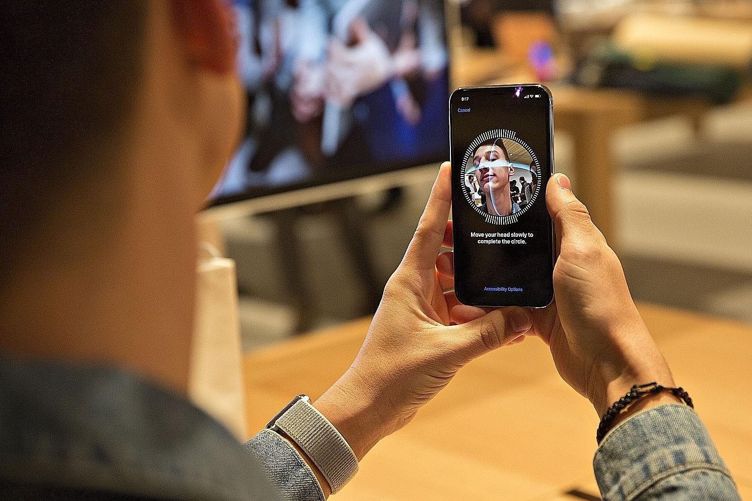 An iPhone X user setting up Face ID on his phone. The phone uses infrared and 3D sensors to make a comprehensive map of a user's face. It is smart enough to detect changes to a face, such as with spectacles or a new beard, but cannot tell identical t
