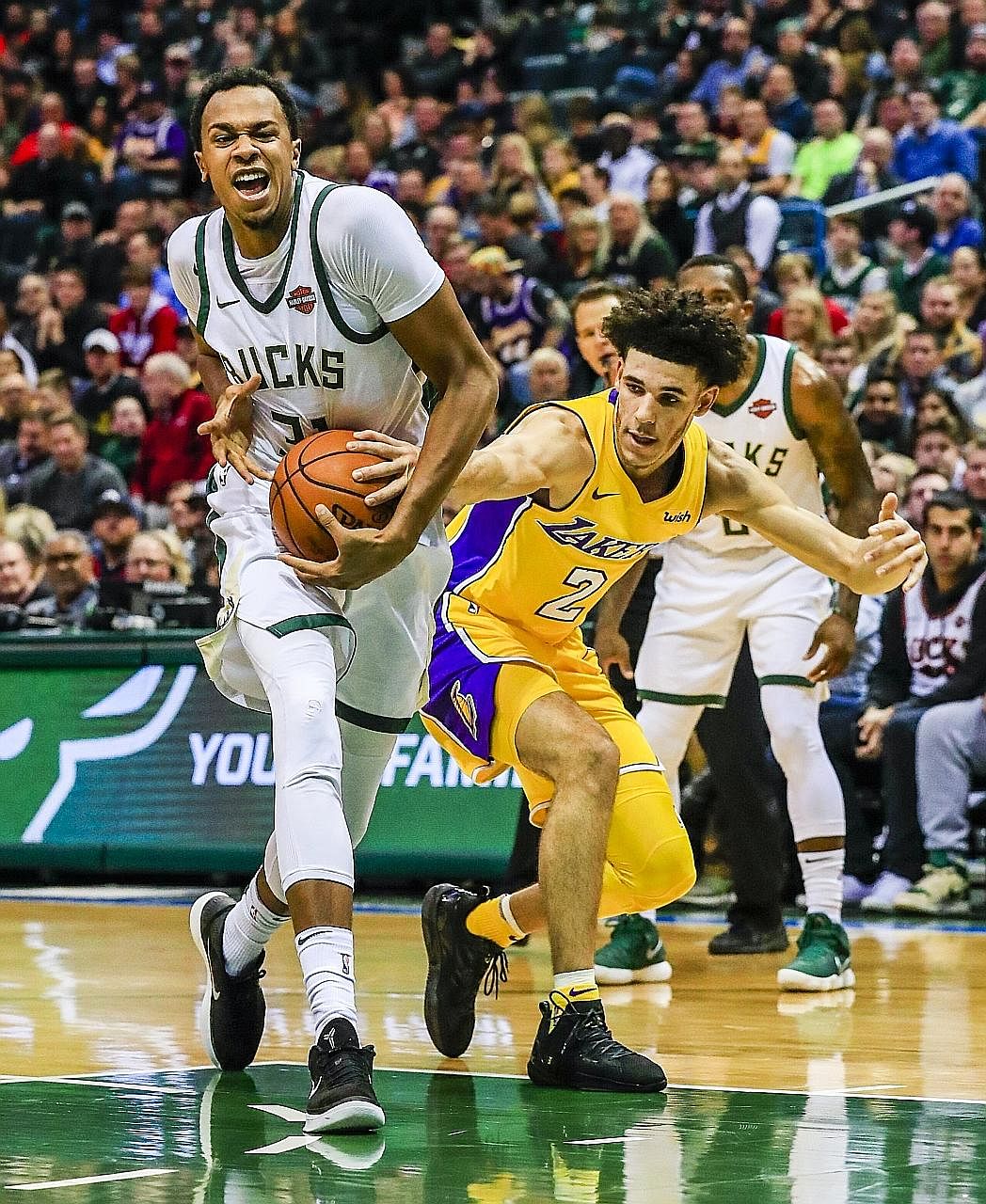 Bucks centre John Henson (left) driving to the basket as Lakers guard Lonzo Ball reaches for the ball in an NBA game in Milwaukee on Saturday. Ball filled up the statistics sheet but could not prevent Los Angeles from losing 98-90.