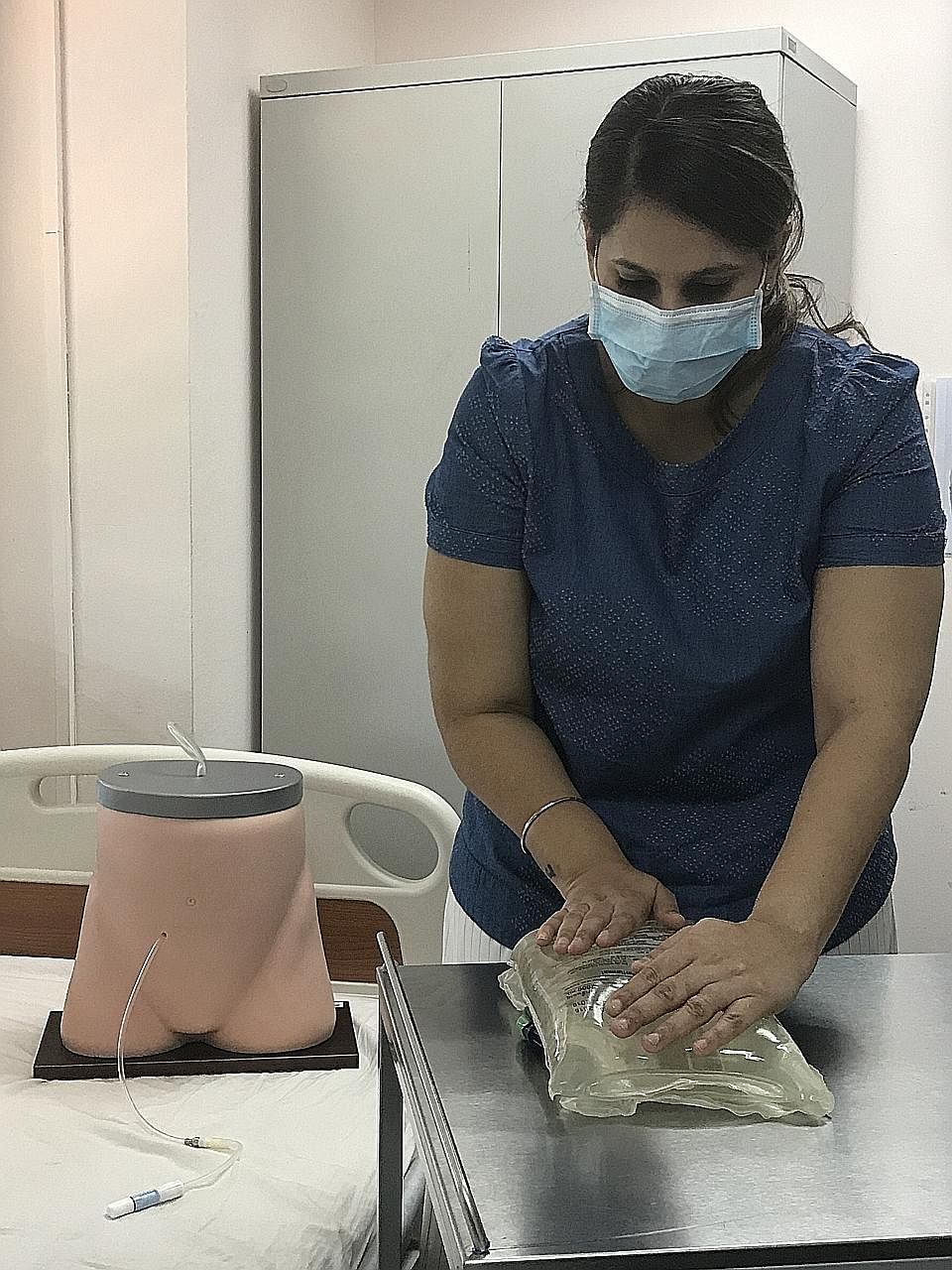 Respite nurse at Active Global Sangeeta Kaur demonstrating steps in the continuous ambulatory peritoneal dialysis process.