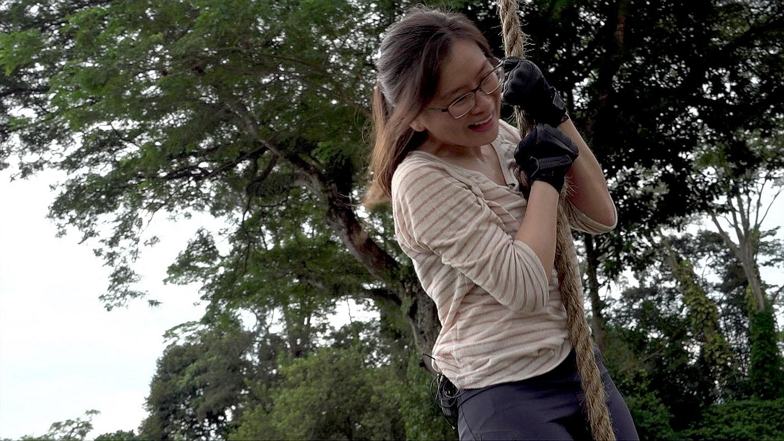 Straits Times journalist Ng Huiwen pulling herself up a rope, scaling a 1.5m-high wall (below), and going through a scenario-based drill - a simulated gunman attack (right) - with officers from the police's elite Emergency Response Team moving in to 