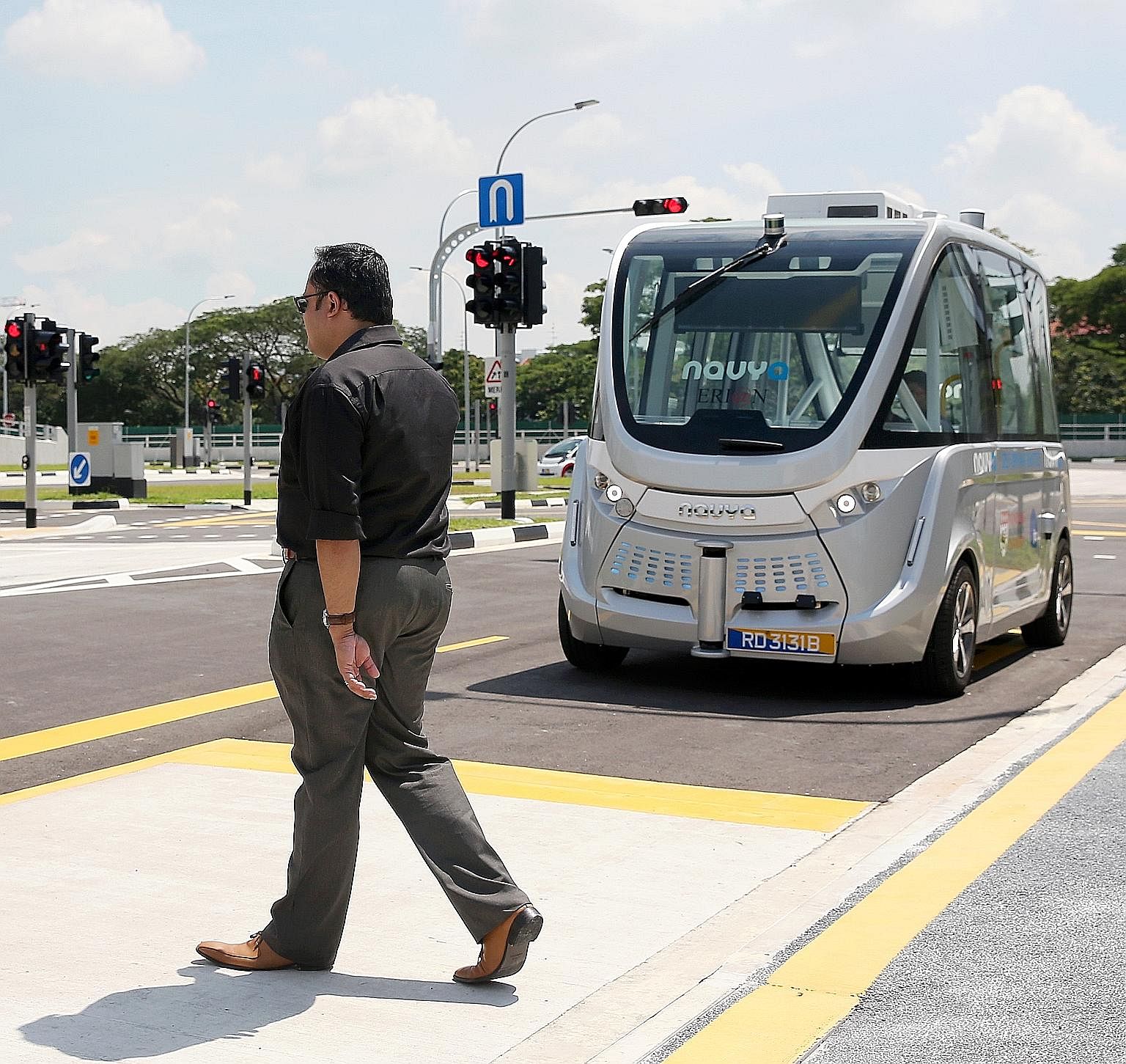 A "jaywalker" strolling in front of a self-driving shuttle bus during a test run. This past week, the Government unveiled plans for robot buses to operate in three towns by 2022.