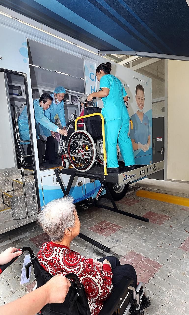 Staff at NTUC Health Nursing Home in Chai Chee helping residents to go for dental care appointments at a mobile clinic run by Unity Denticare parked on the home's premises.