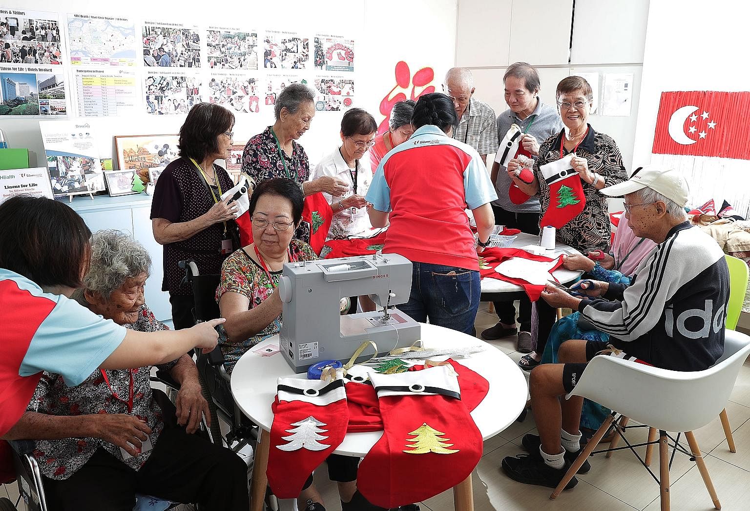 Seniors at the NTUC Health Silver Circle senior care centre in Jurong West making Christmas stockings out of linen from Shangri-La Hotel. The project has helped to improve their physical coordination and attention span.