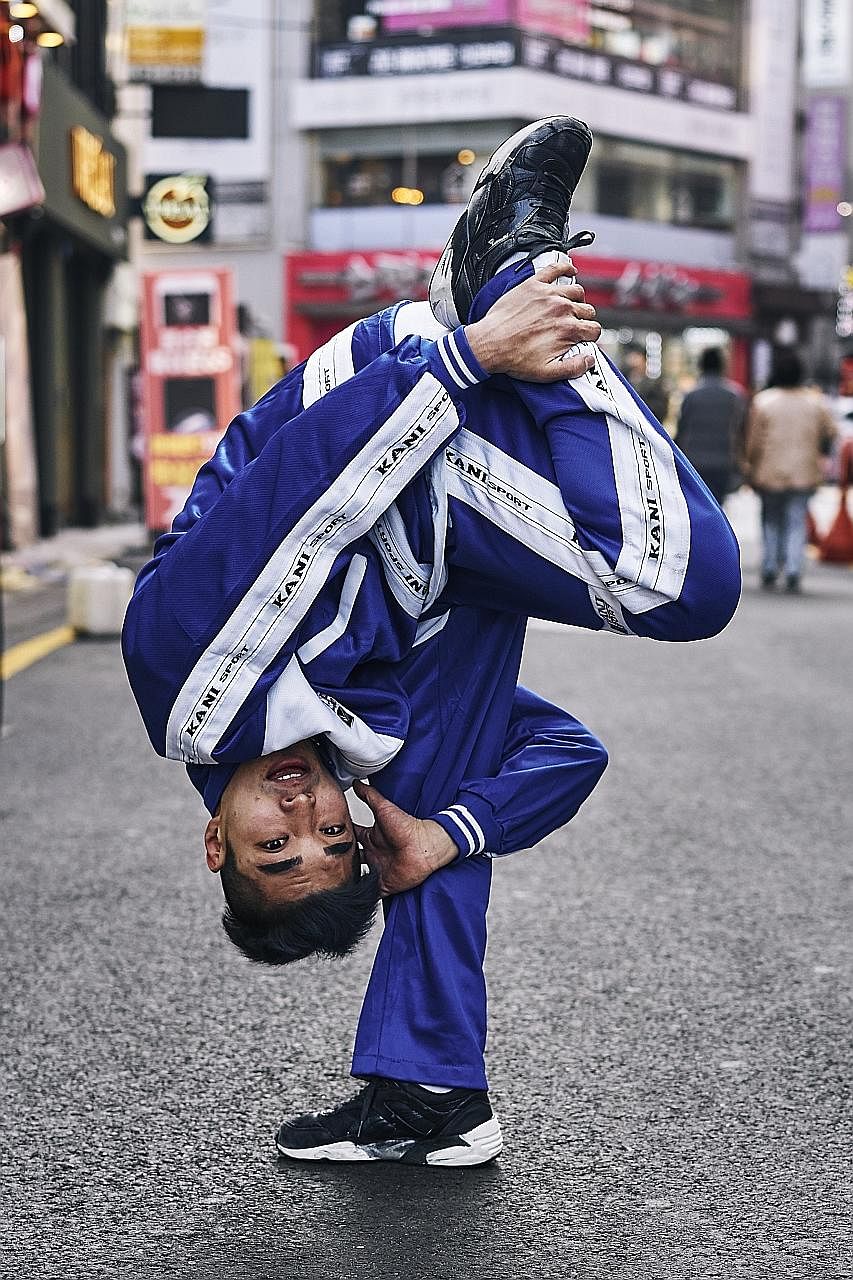 Hong Sung Jin, a member of the South Korean Gamblerz crew who goes by the moniker Pop, shows off a move. Break-dancer Park Woo Sang from Fusion MC strikes a pose in a market in Seoul.