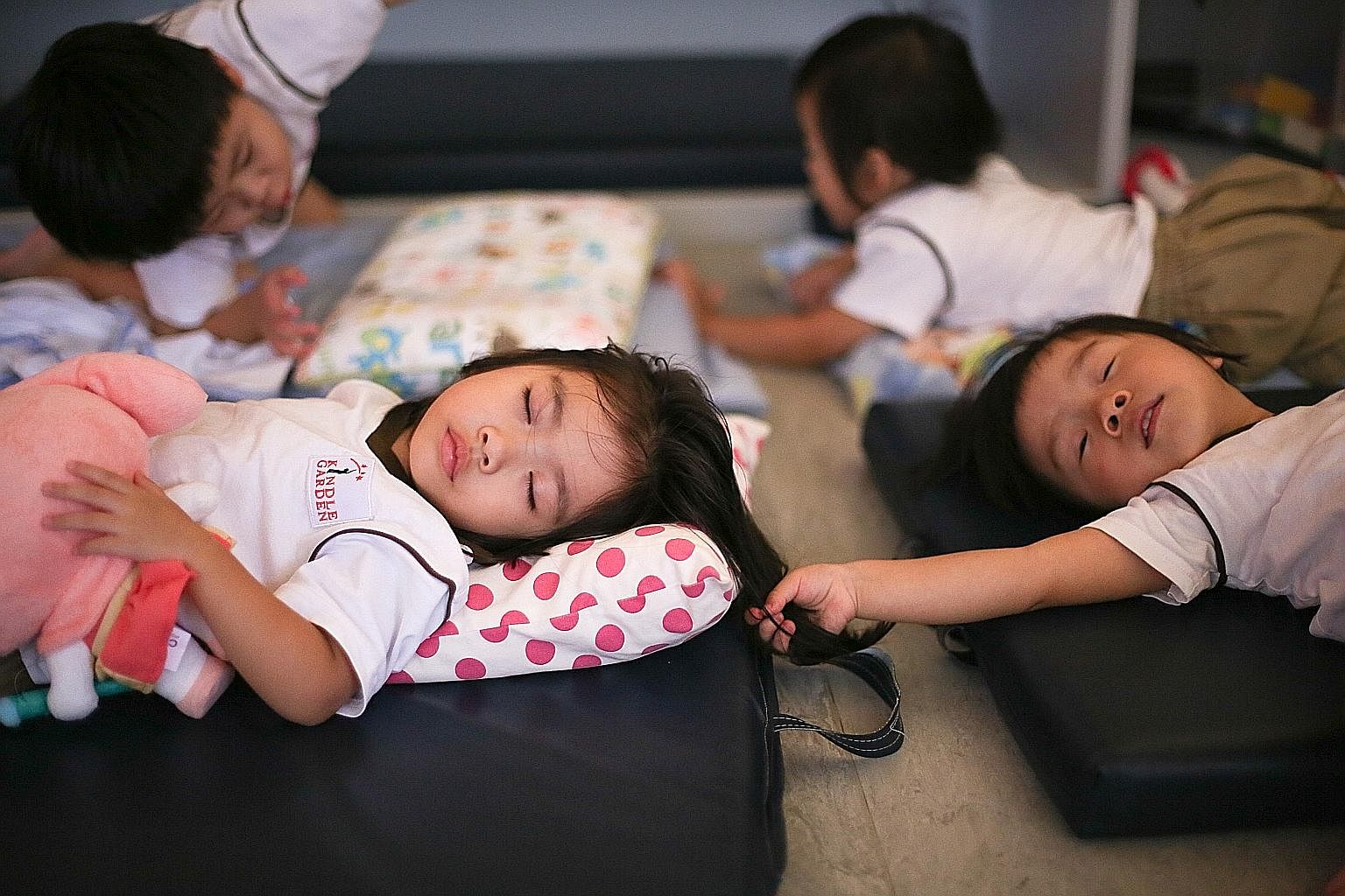 Nursery 1 classmates Oriana Yip (left) and Rhea Lim, both three, take a well-deserved nap after a day of activities and running around. To encourage independence, all the children lay out and put away their beds and sheets themselves. Those who strug