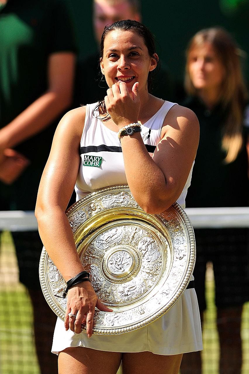 Marion Bartoli with the Venus Rosewater Dish after winning Wimbledon in 2013.