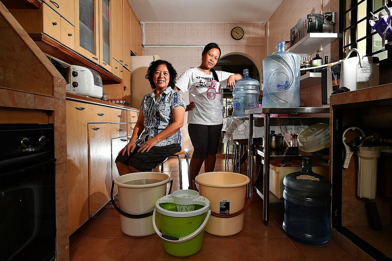 Madam Yeong Soh Yeng, a freelance pre-school teacher, and her Indonesian maid, Madam Fatimah Dulhadi, save water from the washing machine's rinse cycles to wash the floors and flush toilets.