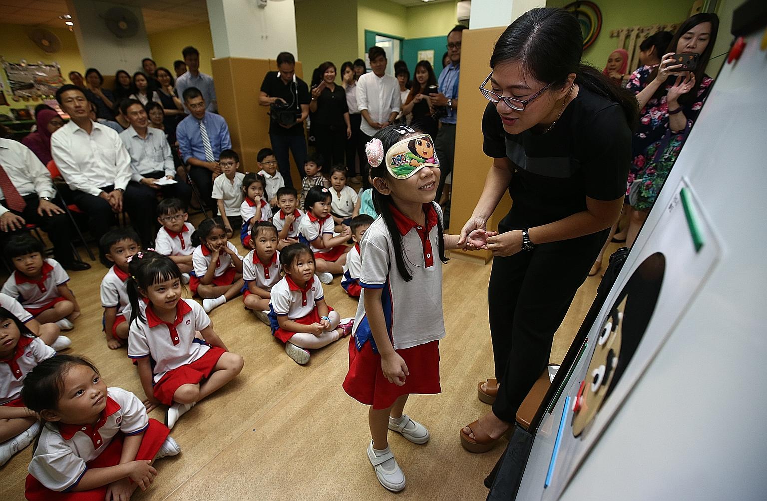 Children at PCF Sparkletots pre-school in Gambas attending a Chinese lesson yesterday using materials designed by the Confucius Institute. Looking on are (seated, from far left) Minister Ong Ye Kung, CI-NTU director Neo Peng Fu and Mr Victor Bay, chi