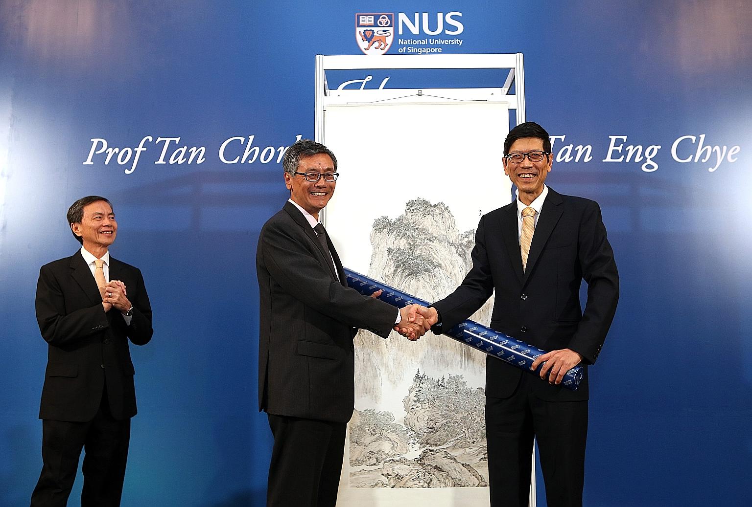 Professor Tan Chorh Chuan (right) presenting a painting he did to NUS president Tan Eng Chye, his successor. In the background is another painting by Prof Tan Chorh Chuan.
