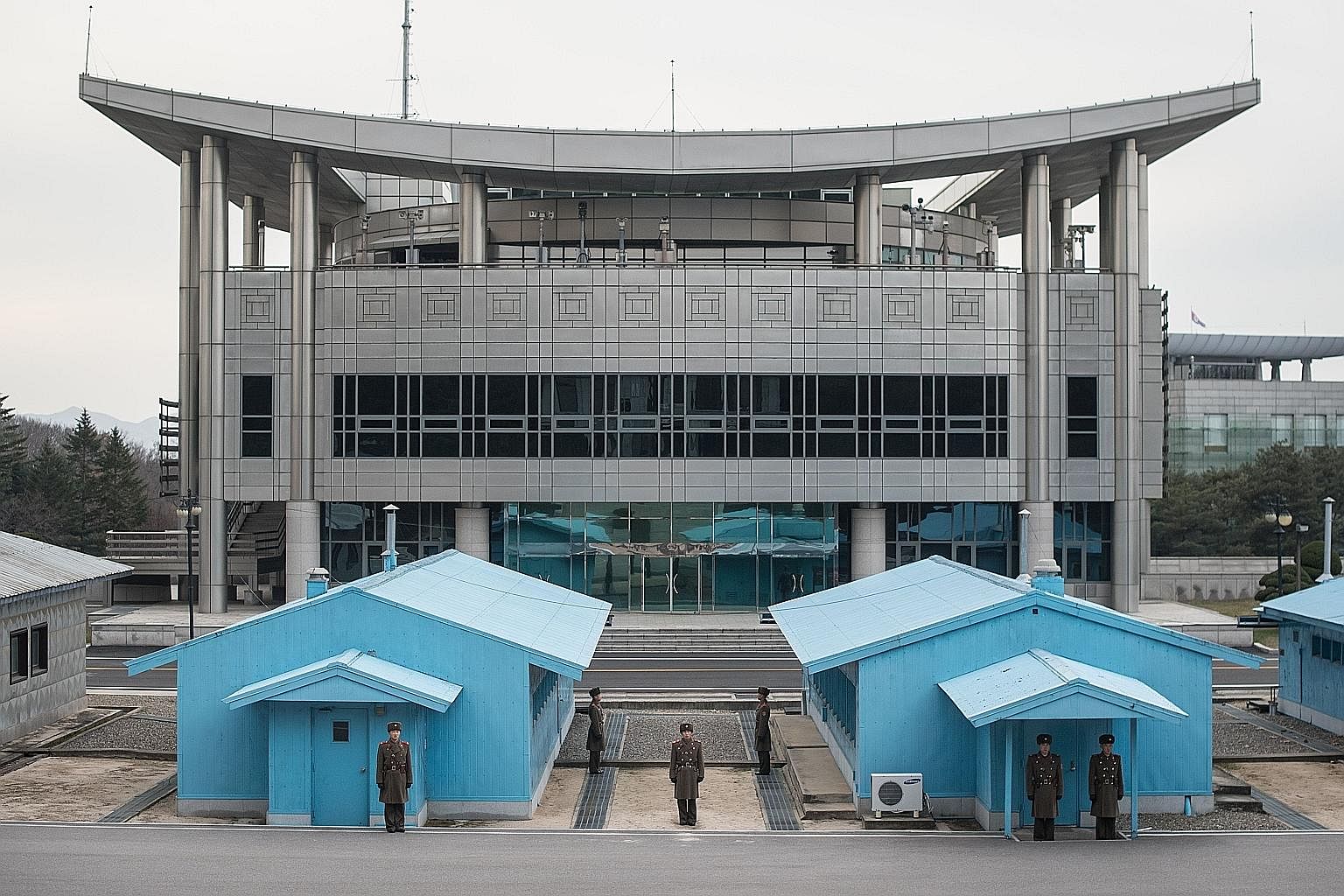 North Korean soldiers standing guard before the military demarcation line and Peace House, proposed as the venue of the upcoming talks between North and South Korea, at the border truce village of Panmunjom.
