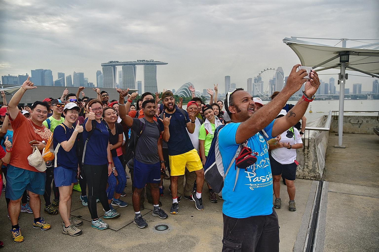 Mr Vijay Kumar taking a wefie of some of the people attempting the 100km walk around the island of Singapore. The group had set off in high spirits from Raffles Place and will walk counter-clockwise round Singapore. They aim to return to Raffles Plac