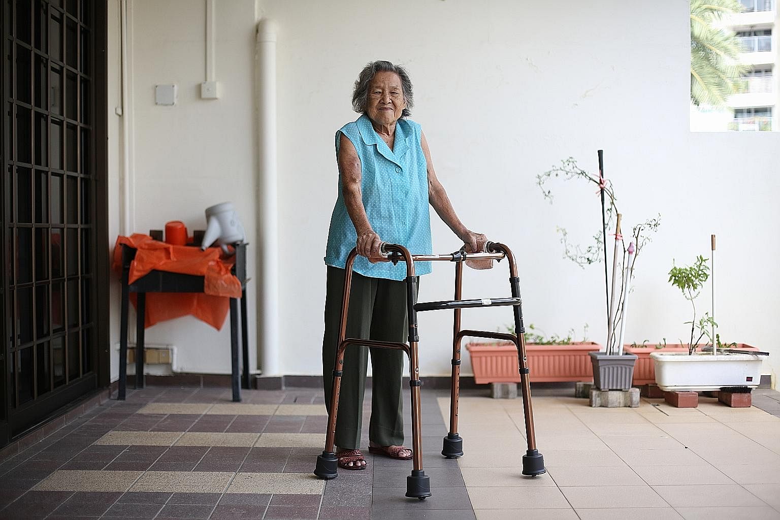 Madam Leck Peow Joo, who suffers from arthritis and end-stage kidney failure, uses the GlydeSafe frame to move around her home. Its retractable wheels allow her to push the frame instead of having to lift it with each step.