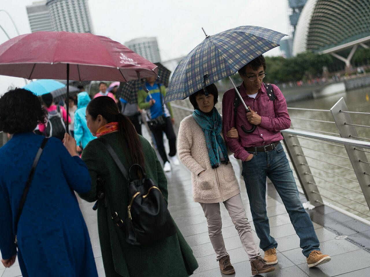 Suitably and warmly dressed for a stroll at Marina Bay in the cool, wet weather. At 21 deg C, we’re reaching for autumn-winter gear. ST PHOTO: ALVIN HO