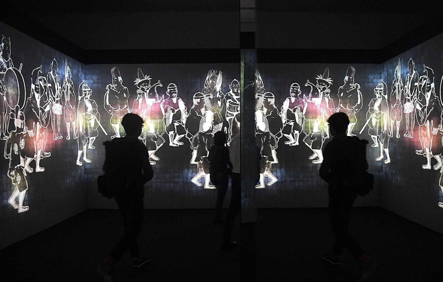 Visitors at an immersive digital installation by teamLab titled Walk, Walk, Walk: Search, Deviate, Reunite in the Ngee Ann Kongsi Concourse Gallery of the National Gallery Singapore. The second Light to Night Festival, led by the National Gallery, re