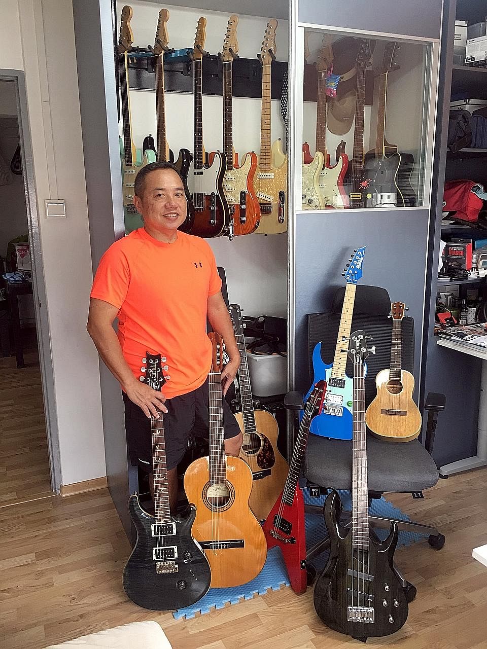 Mr Sim Hong Huat with his collection of 20 stringed instruments, mainly guitars (above), and playing at Eusoff Hall during his university days (left).