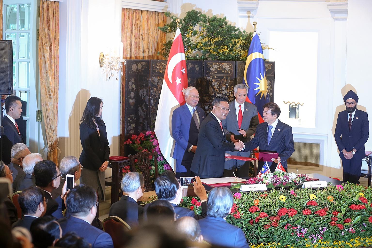 Malaysia's Minister in the Prime Minister's Department Abdul Rahman Dahlan (left) and Singapore's Coordinating Minister for Infrastructure and Minister for Transport Khaw Boon Wan shaking hands yesterday at the Istana after signing a legally binding 