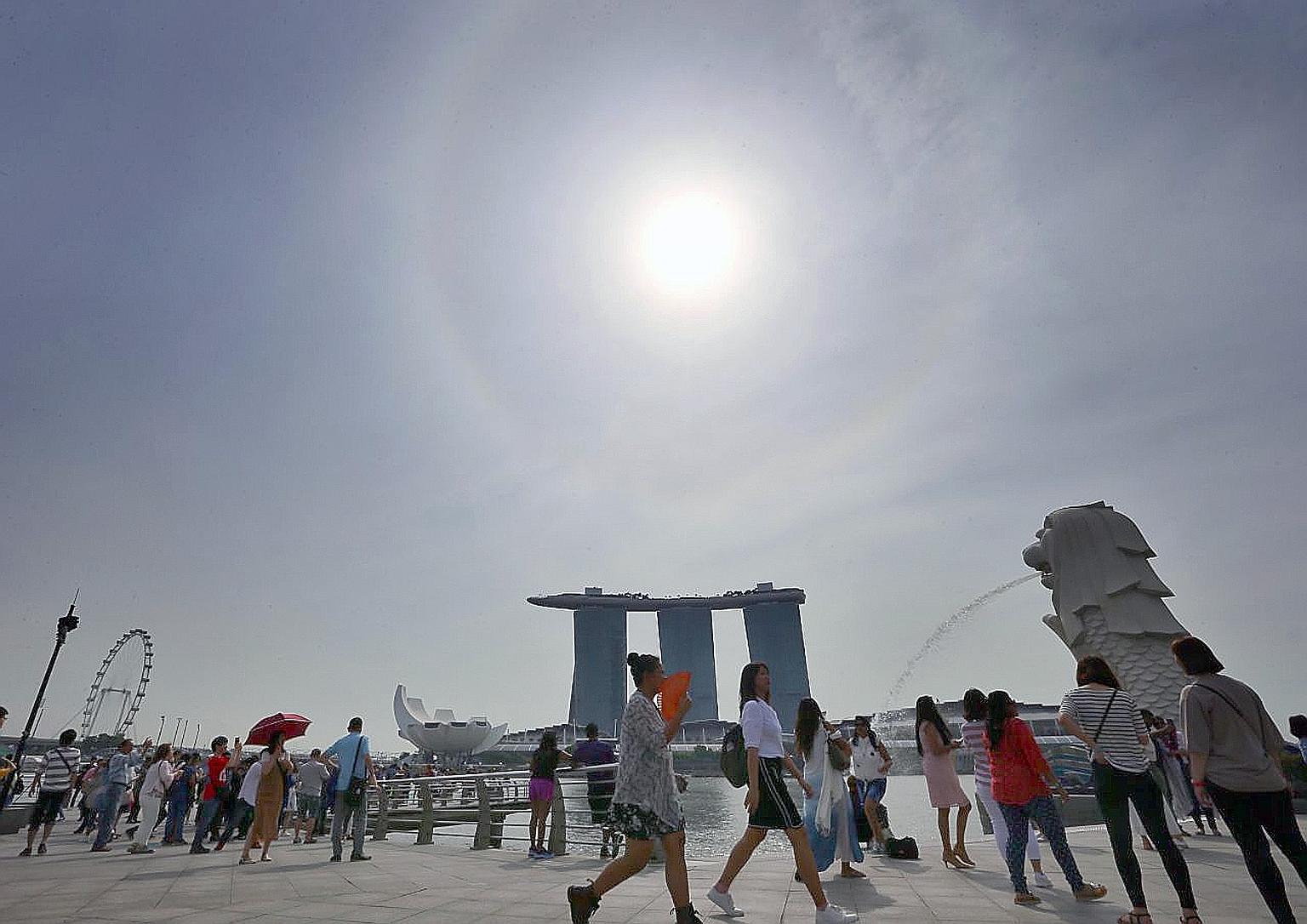 At Merlion Park on Tuesday. Fewer rainy days are expected in the second-half of the month, but rainfall for the month is expected to be well above normal, and daily temperatures will range between 24 deg C and 32 deg C.