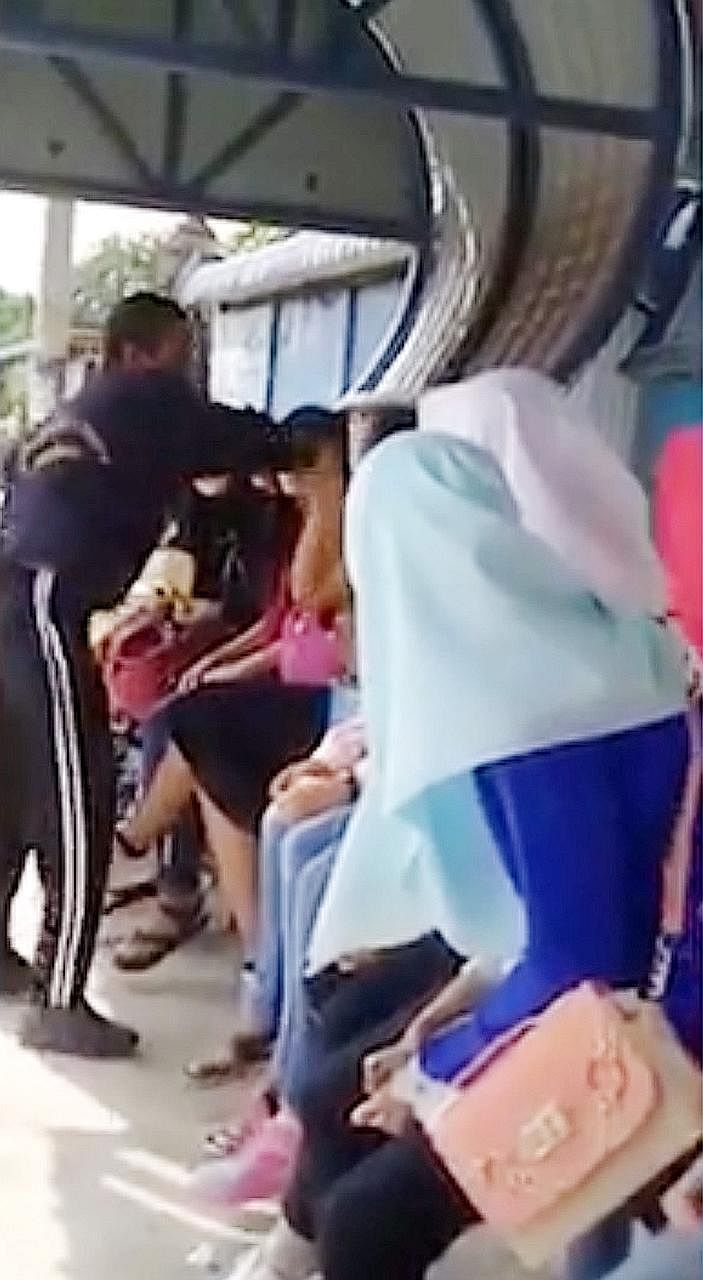 A screen grab from a video showing a man slapping a woman, allegedly for not wearing a headscarf, at a bus stop believed to be in Penang.