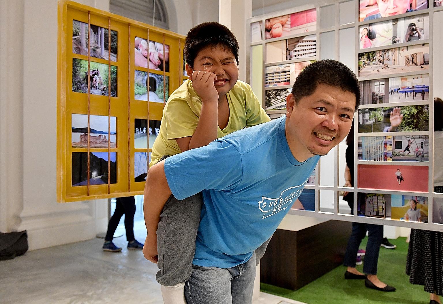 Alfred with former Lianhe Zaobao photojournalist Bob Lee in front of their collaborative work - a series of photos documenting the boy's homes here and in China.