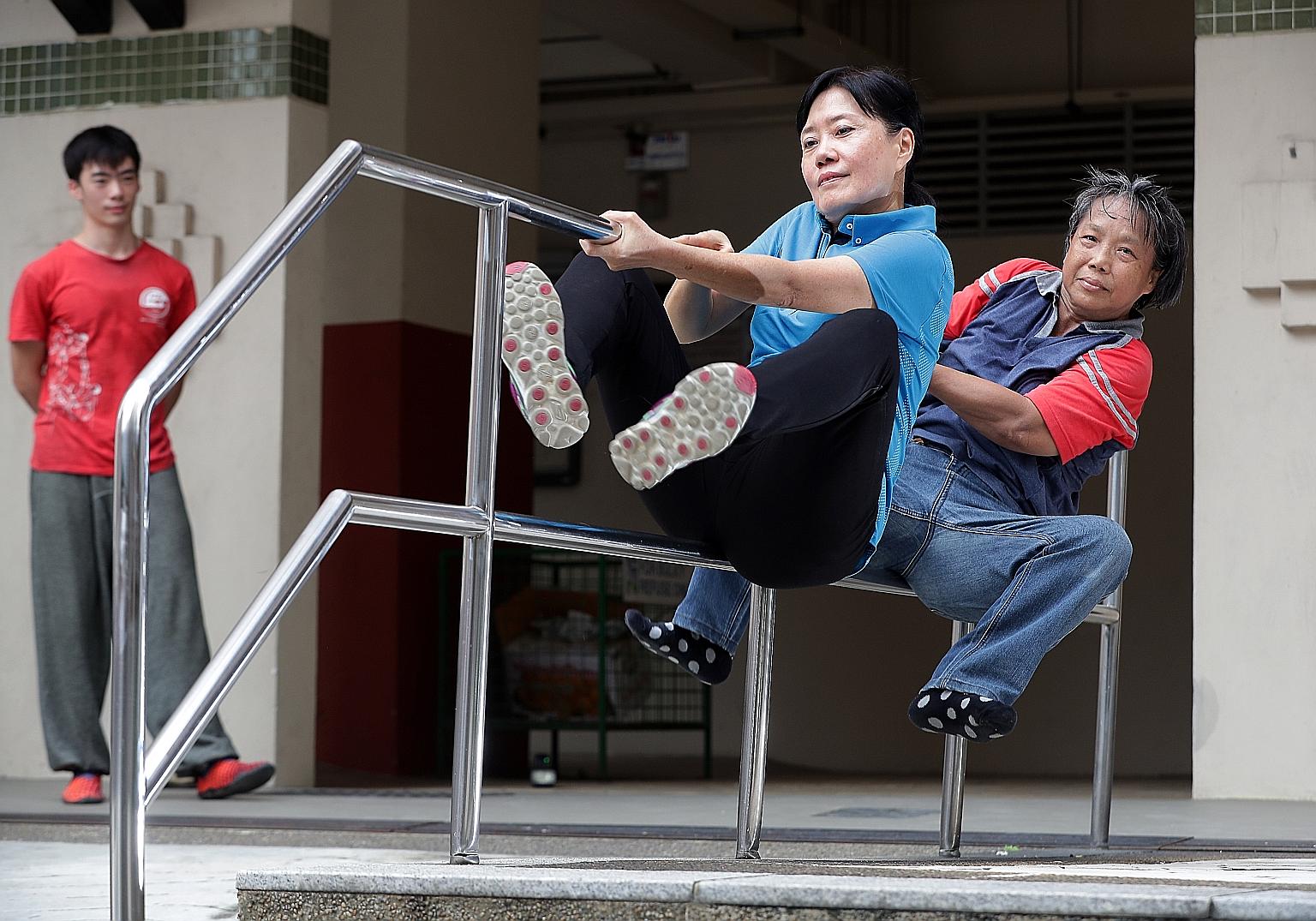 Move Academy Singapore coach Tan Shie Boon keeps a close watch on Madam Kimm Chai (left) and Ms Ann Tham as they execute a parkour move. Both women, who took up the sport last year, say that they have benefited from the training in terms of protectin