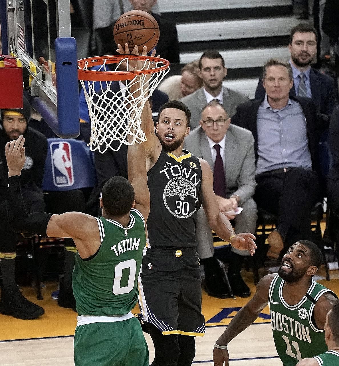 Golden State guard Stephen Curry shoots over Boston forward Jayson Tatum as guard Kyrie Irving looks on during their NBA game at Oracle Arena on Saturday. Curry says he and Irving bring the best out of each other.