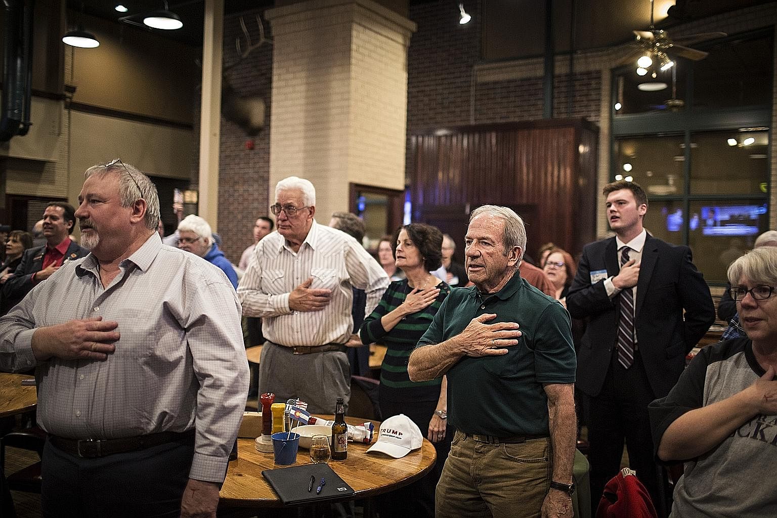 Right: Attendees at a Republican event in Denver, Colorado, saying the pledge of allegiance as they watch a telecast of Mr Donald Trump's State of the Union address. Far right: Mr Trump delivering his speech as Vice-President Mike Pence and House Spe